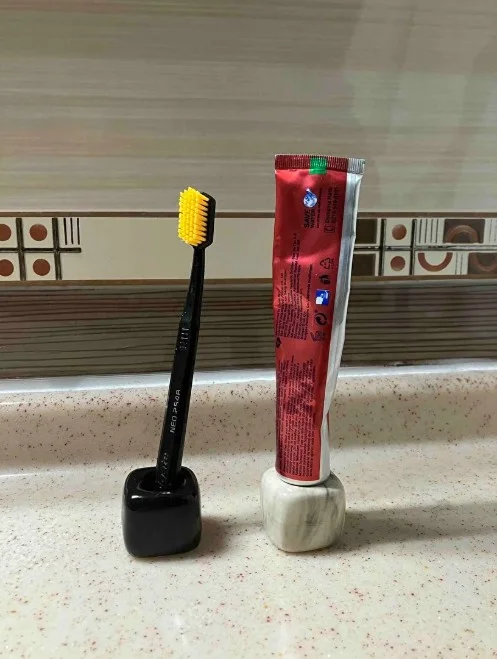 Lavabo kenarında iki diş fırçası ve diş macunuyla Mola Vita tutacaklar